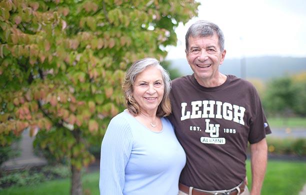 Marty wears a Lehigh shirt and puts his arm around his wife, Joann.