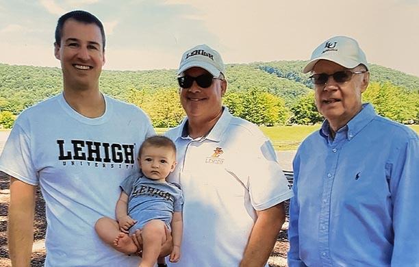 Dan Bayer stands alongside his son Dan Jr. and grandson Dan III all who attended Lehigh. Dan III holds his infant son.