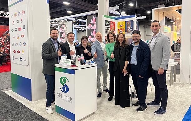 Stu Seltzer and the team from Seltzer Licensing Group all give a thumbs up at a trade show