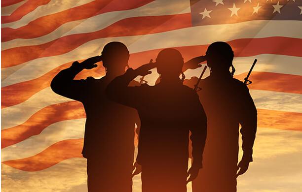 Three soldiers saluting against an American Flag backdrop