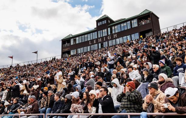 Fans cheering in the stands of Goodman Stadium sporting their brown and white attire.