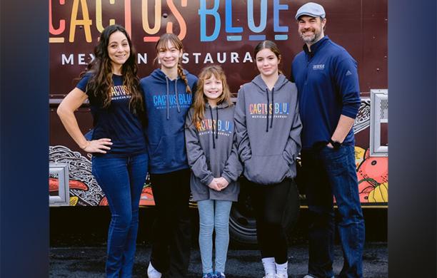 Elizabeth Ortiz with her three daughters and husband standing in front of their food truck