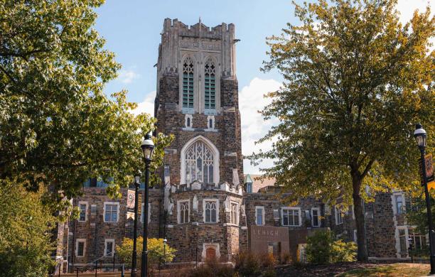 The tower of Alumni Memorial framed by green trees.