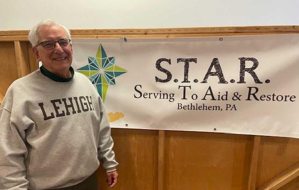 George Harmanos wearing a Lehigh shirt in front of the S.T.A.R. banner