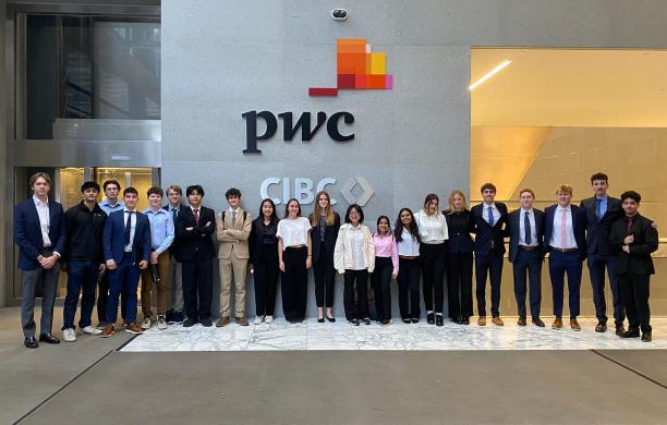 Lehigh students line up below a PwC logo in the NYC office