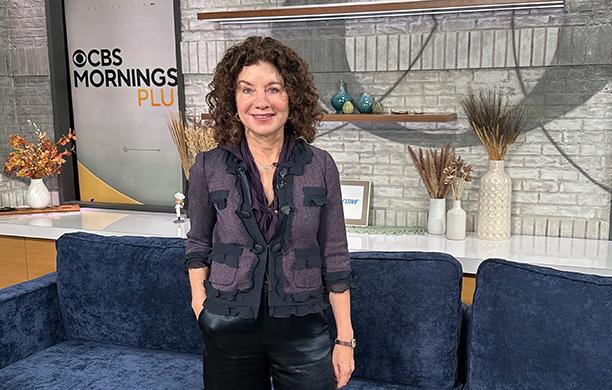 Gail Riess Saltz ’84, in a purple blazer, stands on the set of the CBS Morning program.