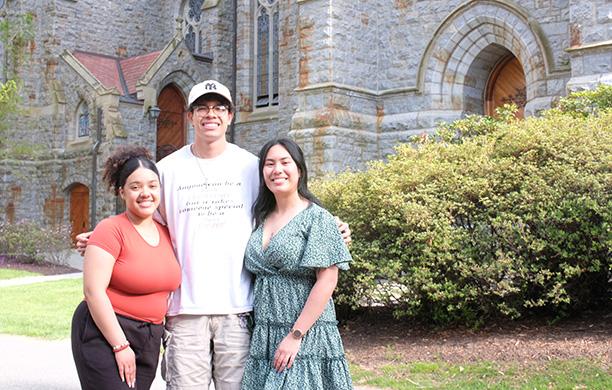Three students stand close together near Packer Memorial Chapel