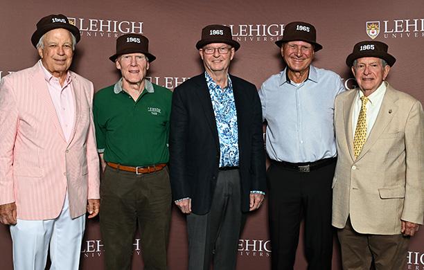 Five men from the Class of 1965 wear Lehigh dinks on their heads and sports coats 