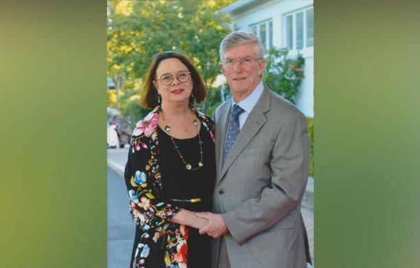 Ellen and Vince Forlenza stand embracing in a suburban environment.