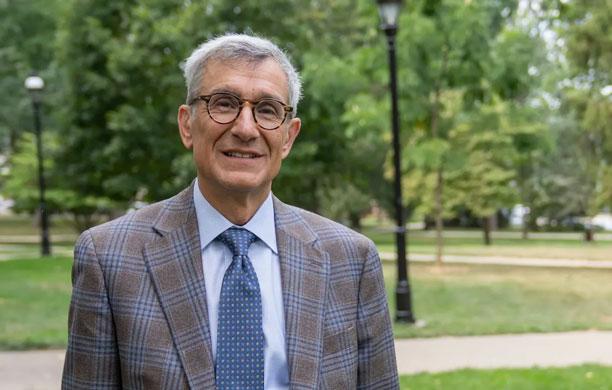 Lehigh president Joseph Helble, dressed in a suit and tie, standing outside on Lehigh's campus.