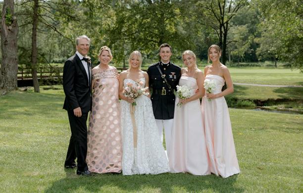 The Hite family pose for a wedding portrait with the parents on the left, the couple in the center, and sisters on the right.