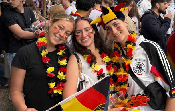 Sofia and friends at a party for the Germany vs Curaçao game during the World Cup. They wear the team colors and merch.