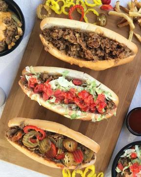 Cheesesteaks with various toppings served on a charcuterie board