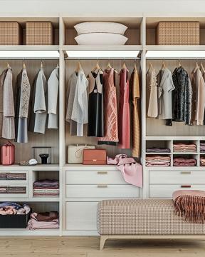 a beautifully organized closet with women's clothing inside