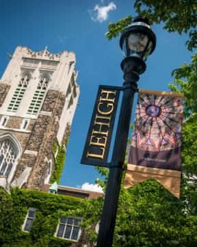 Lamp post with Lehigh flag and building in the background.