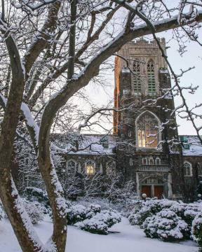 Alumni Memorial tower at sunset, covered in snow.