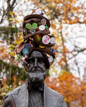 Asa Packer's statue stands tall wearing brown hats adorned with Pins