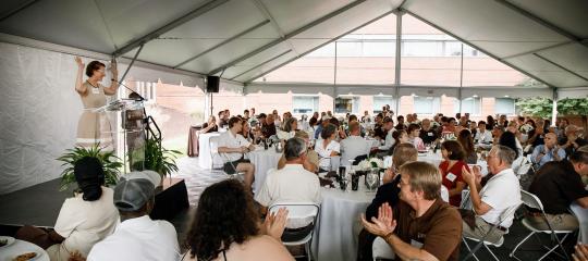 Group of people seated for dinner in a tent