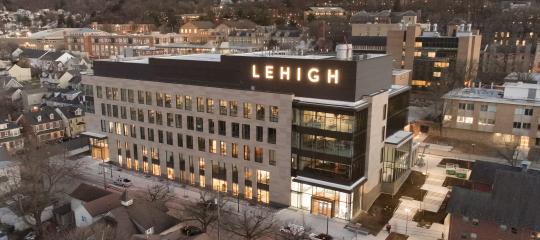 Health, Science, & Technology building lit up at dusk