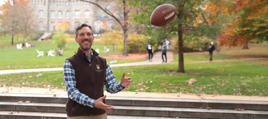 The associate professor of mechanical engineering, Justin Jaworski, catching a football