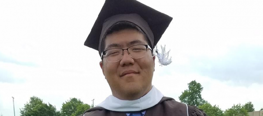 John Lim wears his cap and gown at graduation