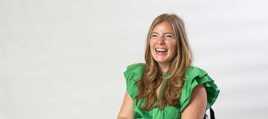 Brooke Eby wearing a large smile and a bright green shirt with ruffles.