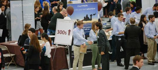 Students and professionals mingle throughout a large open space.