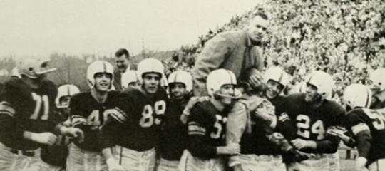 Archived black and white photo of Lehigh football players carrying a coach off the field.