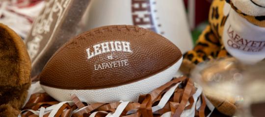 Brown and white foam Lehigh football on a table of other Rivalry decor.