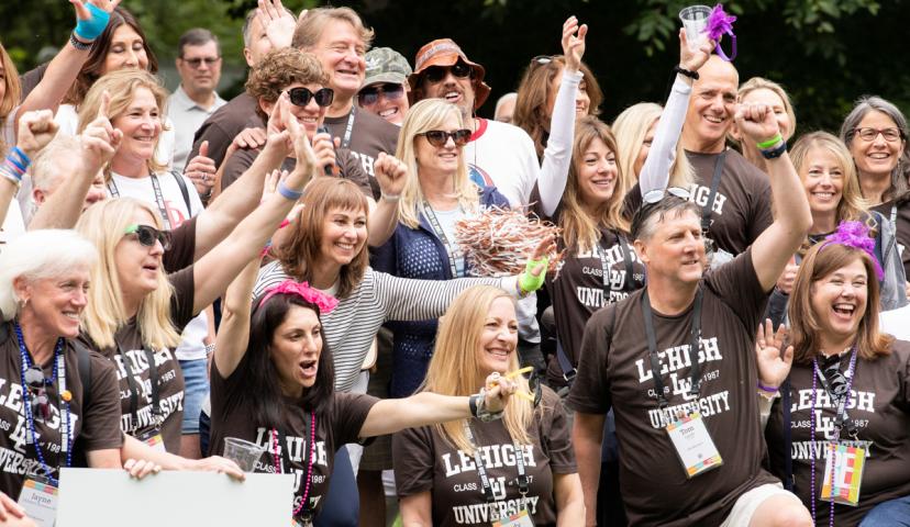 A crowd shot of a group of Lehigh alumni cheering during Reunion Weekend. Heading: Be part of the action.
