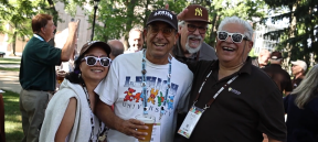 Four Lehigh alumni pose for a group photo during an outdoor Reunion event.