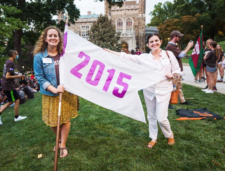 Two alumni with 2015 banner